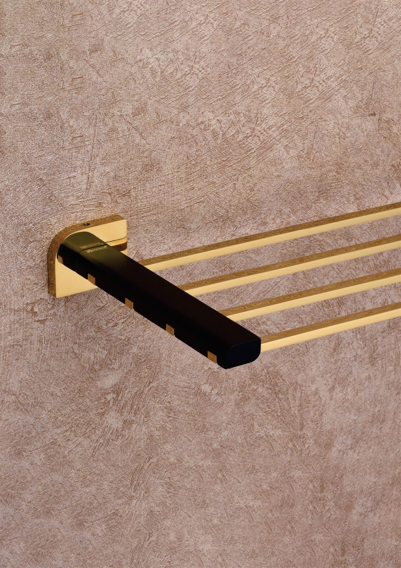 Gold and black towel bar on plaster